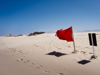 Classifying risk types and asking red flag questions are essential to enterprise risk management. Image of a red flag in the desert. 