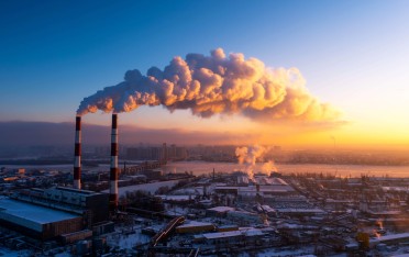 Image of factory against a sunset landscape. Consider your carbon footprint in your decisions. 